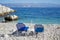 Pair of sunbeds on beauiful turquoise Bataria Beach in Kassiopi, Corfu, Greece