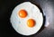 Pair of sunny side up eggs being fried in a pan