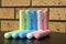 Pair of ten chalks of five different colors on table.
