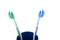 Pair of toothbrushes in blue plastic cup isolated over white background