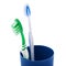 Pair of toothbrushes in blue plastic cup isolated over white background