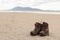 Pair of trekking boots on a remote beach with sea and mountains