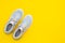 Pair of trendy sport sneakers on yellow background. Top view with copy space