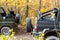 Pair of two 4x4 soviet suv covertible top vehicle on dirt gravel unpaved road in summer at sunset morning sun. Off road