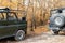 Pair of two 4x4 soviet suv covertible top vehicle on dirt gravel unpaved road in summer at sunset morning sun. Off road