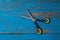 A pair of used children scissors against old blue wooden background