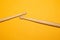 Pair of used drumsticks on yellow background