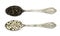 Pair of vintage spoons with seeds of black and white dry pepper isolated on white top view