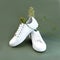 Pair of White sneakers on green background. Concept of healthy lifestyle and food, everyday training and force of will.