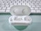 Pair of White Wireless Ear Buds in Dock on Table with Blurred Keyboard Background