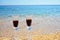 Pair of wine glasses on the beach. Two crystal glasses of wine On The yellow Sandy Beach Near ocean