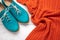 Pair of womens aqua oxfords and orange pullover on white wooden background. Flat lay, casual trendy style concept. Fashion clothes