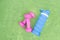 Pair of womens pink matte dumbbells for sports and silicone water bottle on green background