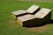 Pair of wooden benches on the lawn in the sunlight in public park