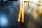 Pair of wooden drumsticks on wooden table small defocused on top. Colourful shadows of studio sofit. Hobbies and music