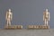 Pair of wooden human figures standing on cubes with the text Social Distance