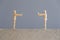 Pair of wooden human figures standing at a safe distance from each other