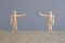 Pair of wooden human figures standing at a safe distance from each other