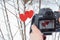 Pair of wooden red hearts on snowy tree with reflection in camera screen. Photography hobby concept. Love and romantic concept.
