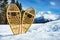 Pair of the wooden snowshoes in snow over mountain peaks