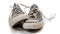 A pair of worn out gray sneakers on a white background