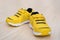 Pair of yellow sporty shoes for kid on wood