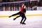 A pair of young athletes-skaters performs parallel glide.