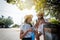 A pair of young beautiful happy travelers in hats, a man and a woman, with mobile phones in hands.