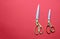 Pairs of scissors gold handle isolated on red background, top view