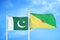 Pakistan and French Guiana two flags on flagpoles and blue cloudy sky