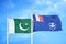 Pakistan and French Southern and Antarctic Lands two flags on flagpoles and blue cloudy sky