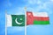 Pakistan and Oman two flags on flagpoles and blue cloudy sky