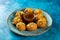 Pakistani spicy gol gappay, indian pani puri and bangali fuchka full of chaat masala with sour water in a dish isolated on marble