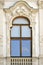 Palace window with exquisite stucco ornament. Rich decoration of old historical building in Belvedere Palace. Vienna, Austria.