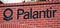 Palantir logo and sign is displayed on brick wall