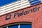 Palantir logo and sign is displayed on brick wall