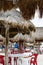 Palapa shades on the beach with plastic tables and chairs under them - Focus on the foreground with blurred background with uniden