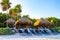 Palapa thatched roofs palms parasols sun loungers beach resort Mexico