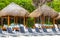 Palapa thatched roofs palms parasols sun loungers beach resort Mexico