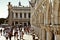 Palazzo Ducale and other classic Venetian architecture with tourists walking in front on the Piazza San Marco. Close up view of