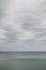 Pale cloudy sky over dim greyish sea water