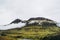 Pale green bold mountains covered with gray clouds. Splendid Icelandic landscapes