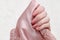 Pale pink satin textile in female hand. Beauty manicure. Fashion