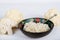 Paleo organic vegetarian food cauliflower rice in a floral rustic bowl, on white background