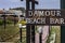 Paleokastritsa, Cofru, Greece- MAY 10, 2018 Damour Beach Bar Name board is shown at the entrance of the Bar. the walkways, gardens