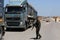 Palestinian security officers stand next to Palestinian trucks at a checkpoint before heading to the Israeli side at the Kerem Sha