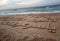 A Palestinian youth writes in sea sand the name of the late Palestinian President Yasser Arafat, to commemorate his death