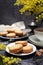 Palets bretons, french cookies. Shortbread Breton cookies, cup of tea and bouquet of mimosa