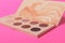 Palette of colorful eye shadows. Pink background