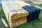 Pallet with long round natural wooden fence posts with tarred and sharpened ends